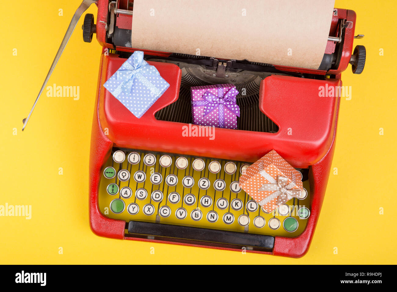 Holidays concept red typewriter with blank craft paper, gift boxes on