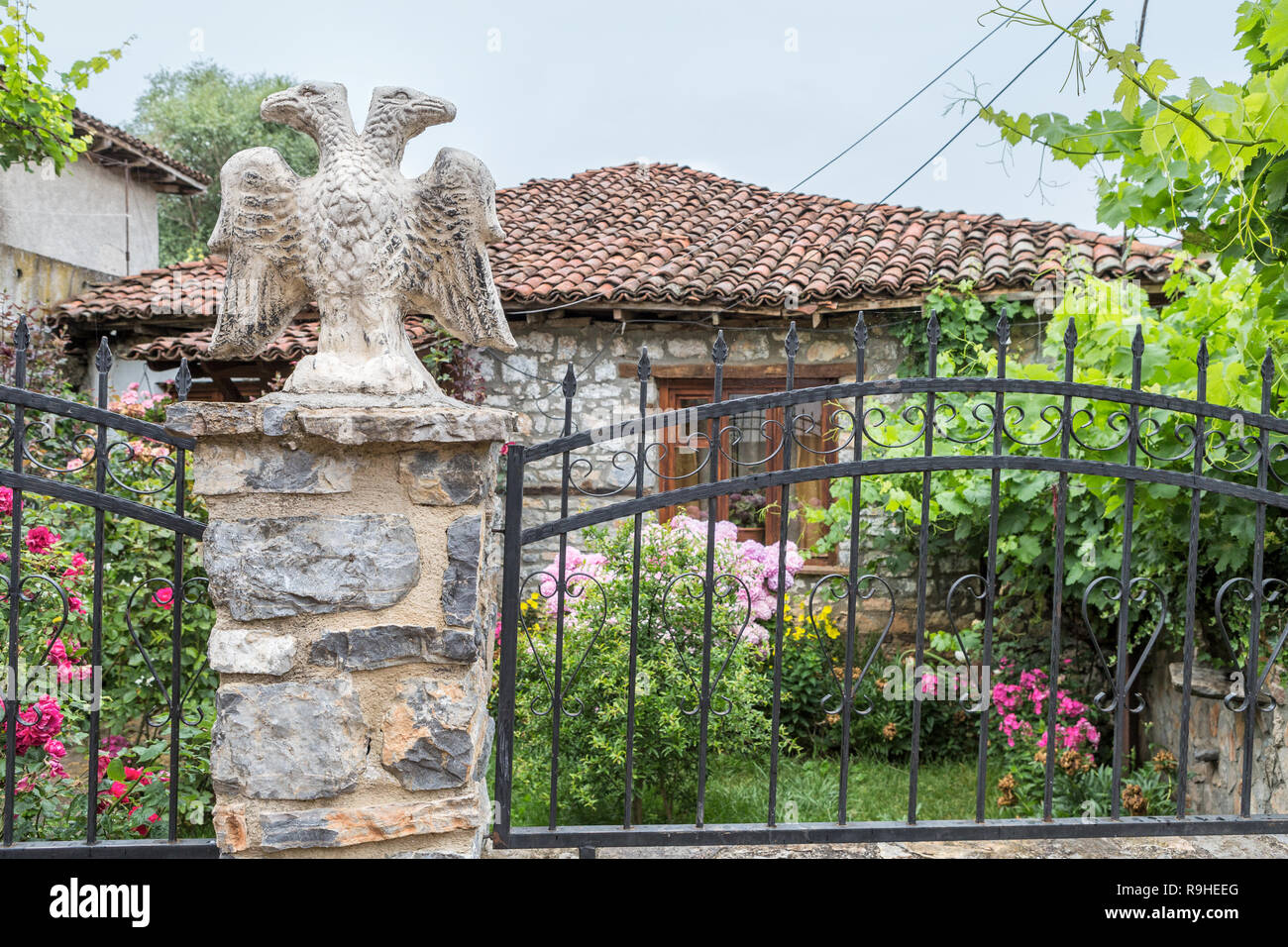 Lin village garden with statue of Albanian Double headed Eagle  Albania Stock Photo