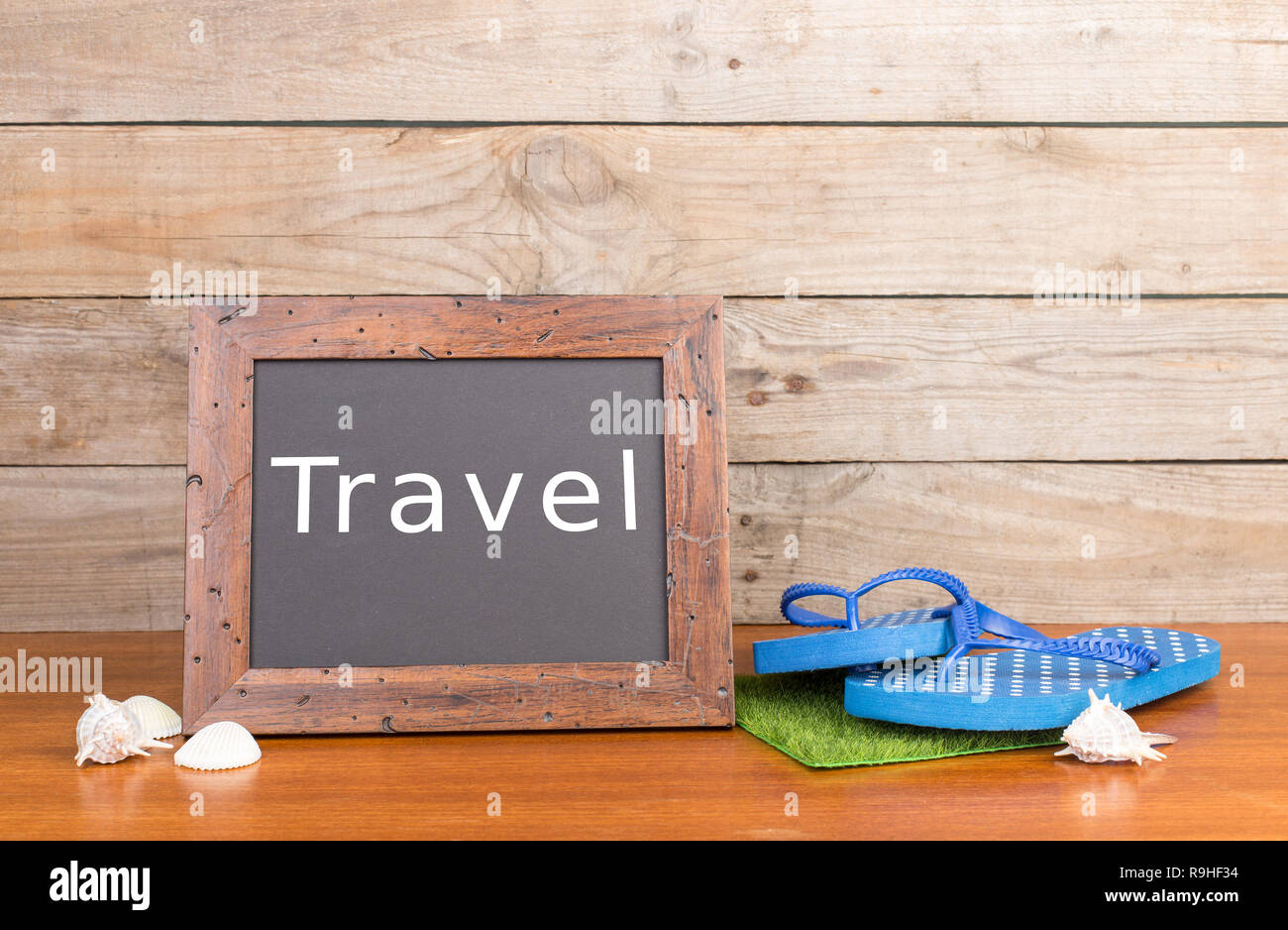 Travel concept - flops, seashells and blackboard with inscription 'Travel' Stock Photo