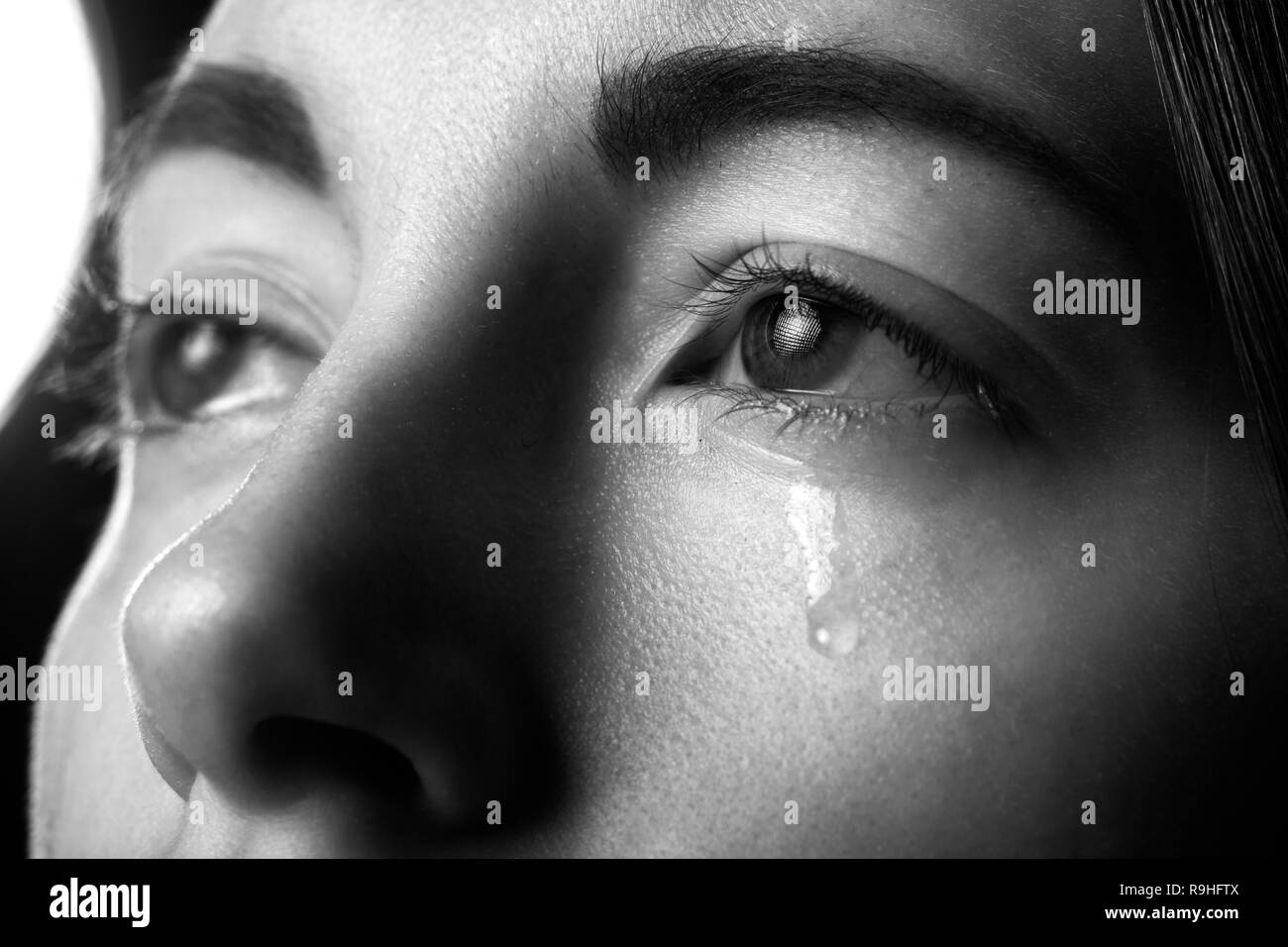 sad woman crying on black background, looking up, closeup portrait, monochrome Stock Photo