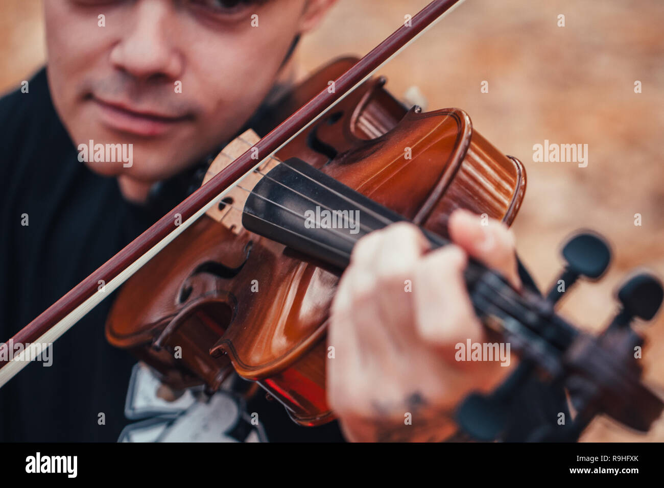 young man playing violin in the autumn forest. Stock Photo