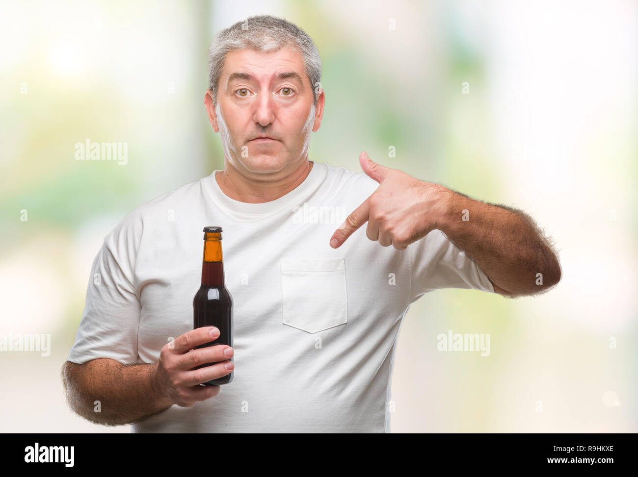 opraken Beven Kennis maken Handsome senior man drinking beer bottle over isolated background with  surprise face pointing finger to himself Stock Photo - Alamy