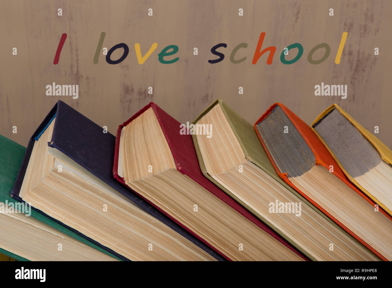 Back to school and education concept - colorful hardback books on brown background with text 'I love school' Stock Photo