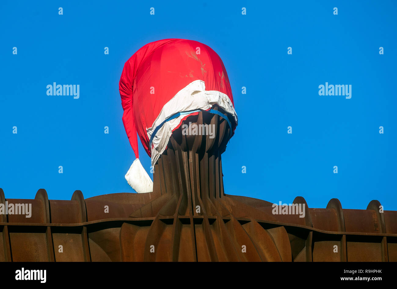 A Santa hat on the 20 metres tall steel sculpture 'Angel of the North', outside Gateshead, Tyne and Wear, in NE Engand. Stock Photo