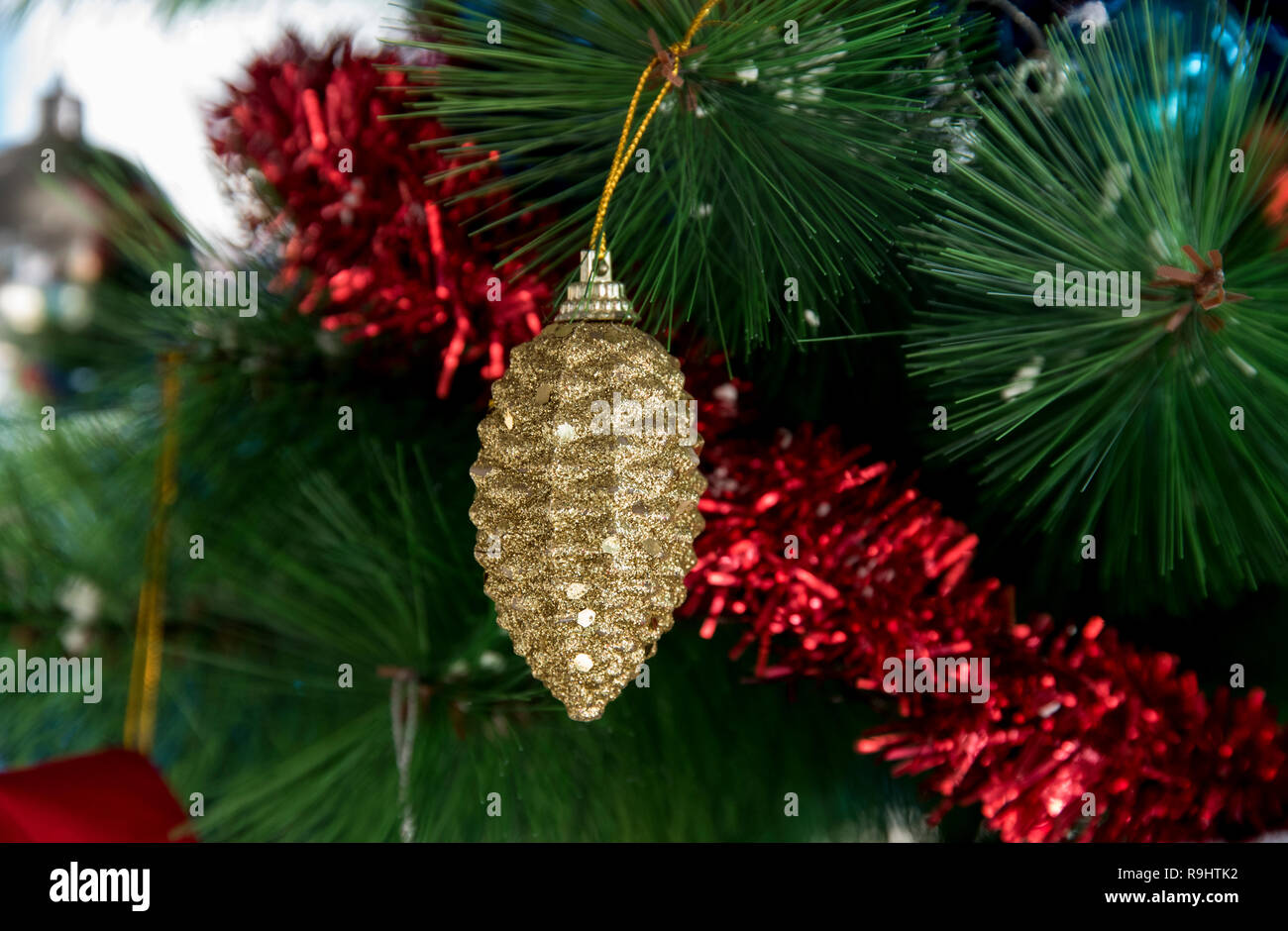 Sparkling golden ball hanging on christmas tree Stock Photo