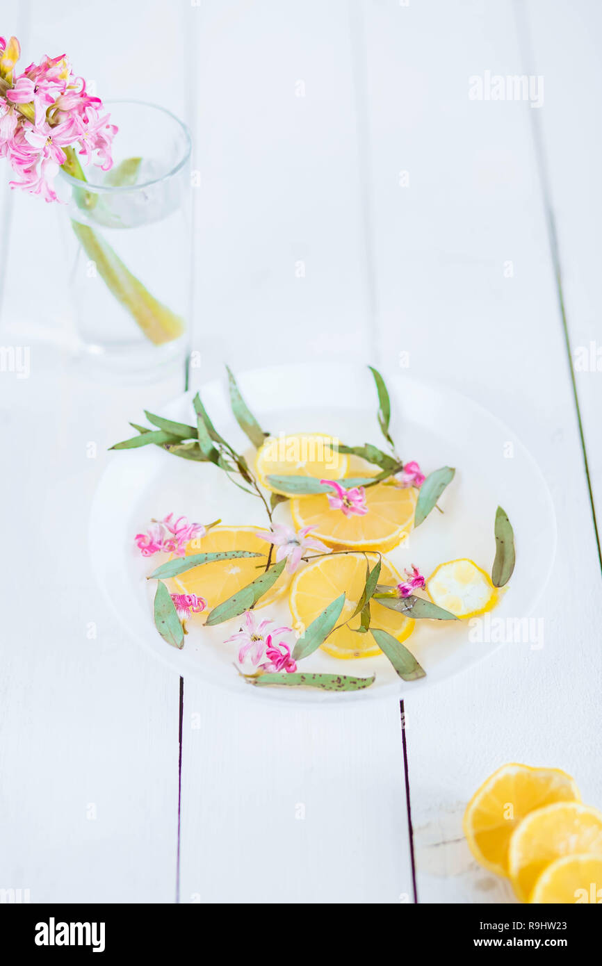 Foot bath in bowl with lime and tropical flowers, spa pedicure