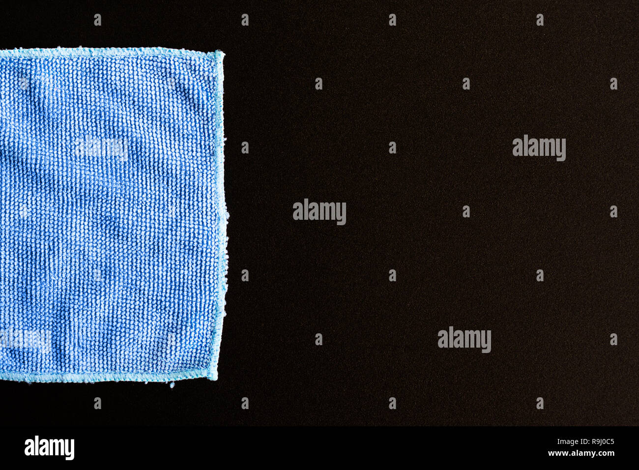 Blue folded microfiber cloth on black table Stock Photo