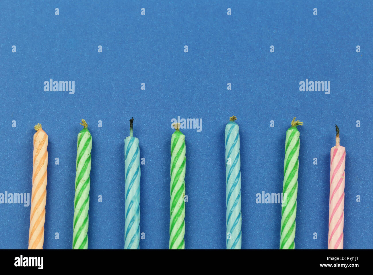Small candles on blue paper background and have copy space for design ...