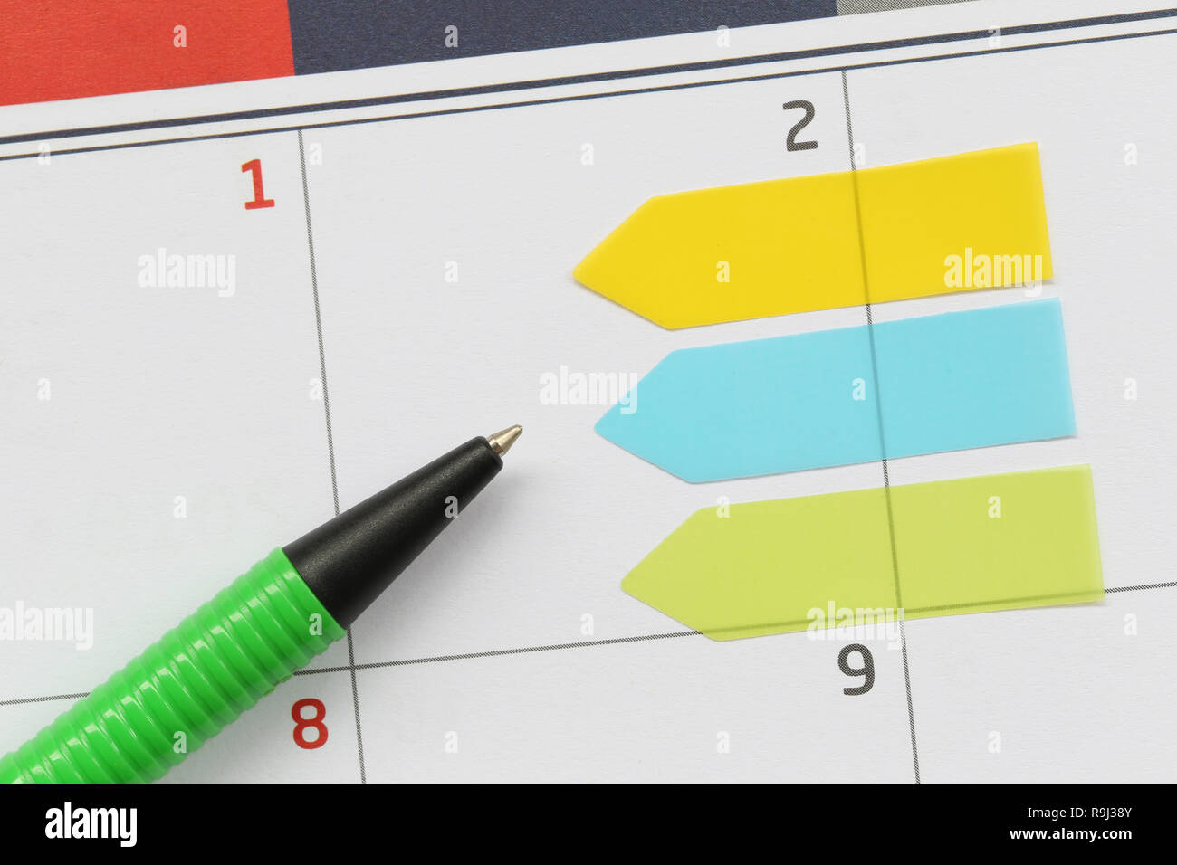 Green pen points to a empty area on the calendar background of 2nd day for design in your work concept. Stock Photo