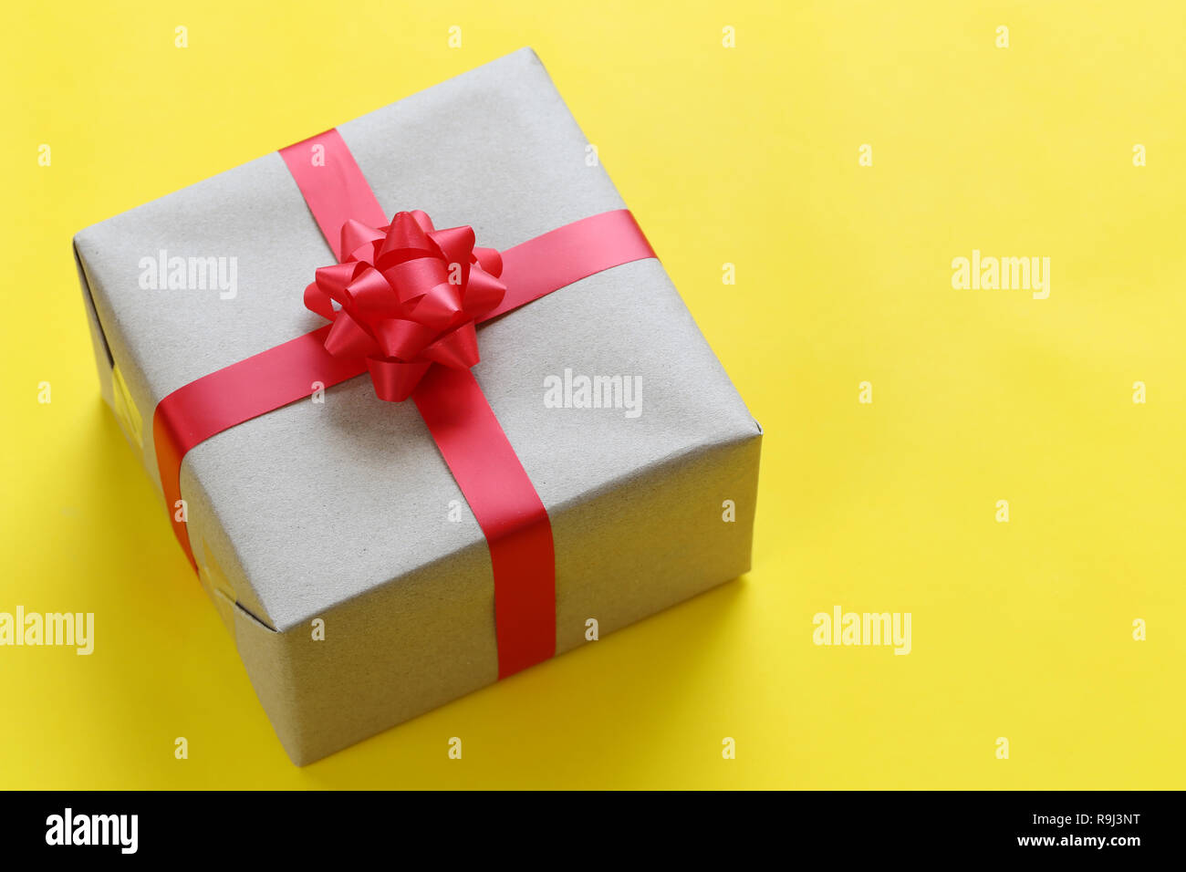 Brown Christmas gift box placed on a yellow art paper floor and have copy space for design in your work Important day concept. Stock Photo
