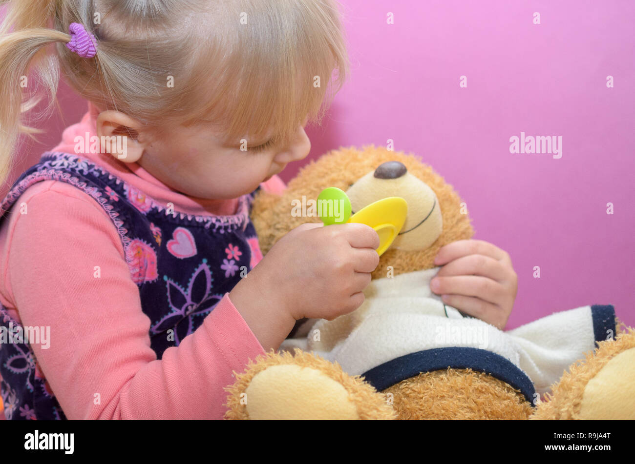 The little girl is playing with any soft toys Stock Photo - Alamy