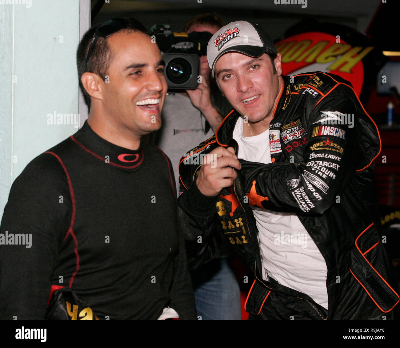 Juan Pablo Montoya (L) jokes with teammate David Stremme as he awaits his turn to test a NASCAR Nextel Cup car after recently signing to drive for Chip Ganassi racing, at Homestead Miami Speedway in Homestead, Florida on October 17, 2006. Stock Photo