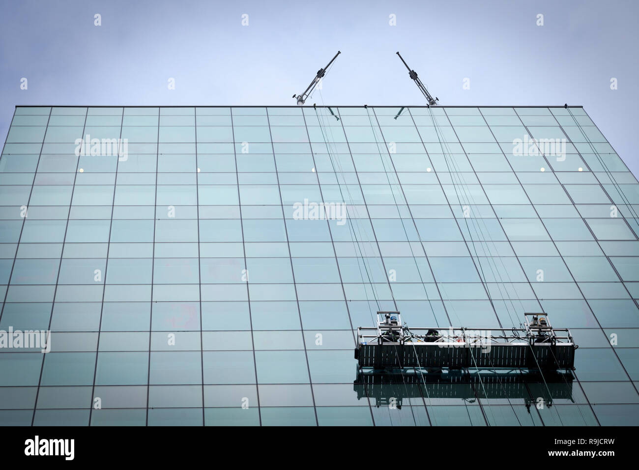 Windows washers on their cleaning platforms operating on a high rise skyscraper office tower in the city center of Ottawa, Ontario, Canada, one of Ame Stock Photo