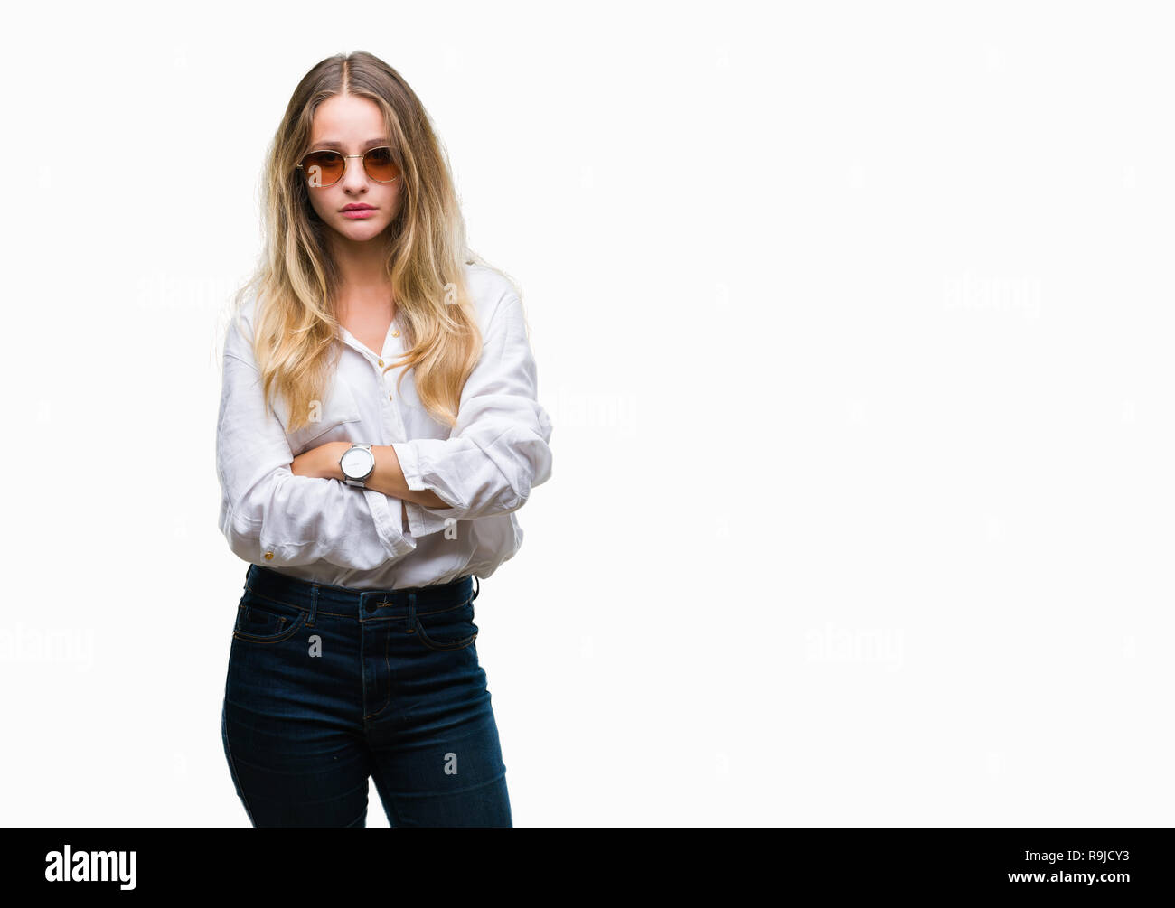 Young beautiful blonde woman wearing sunglasses over isolated background skeptic and nervous, disapproving expression on face with crossed arms. Negat Stock Photo