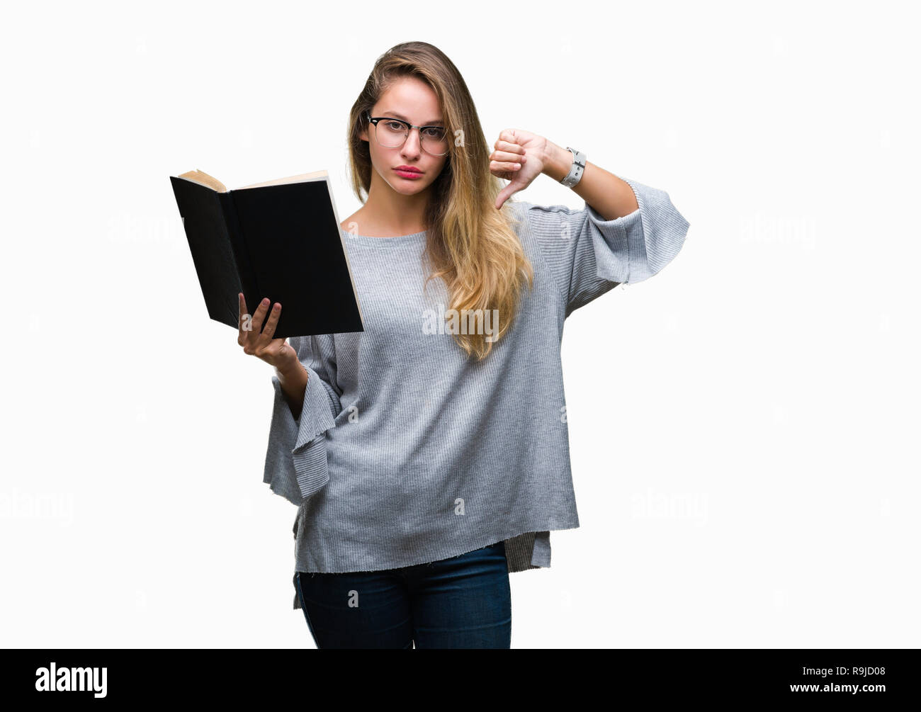 Young beautiful blonde woman reading a book over isolated background ...