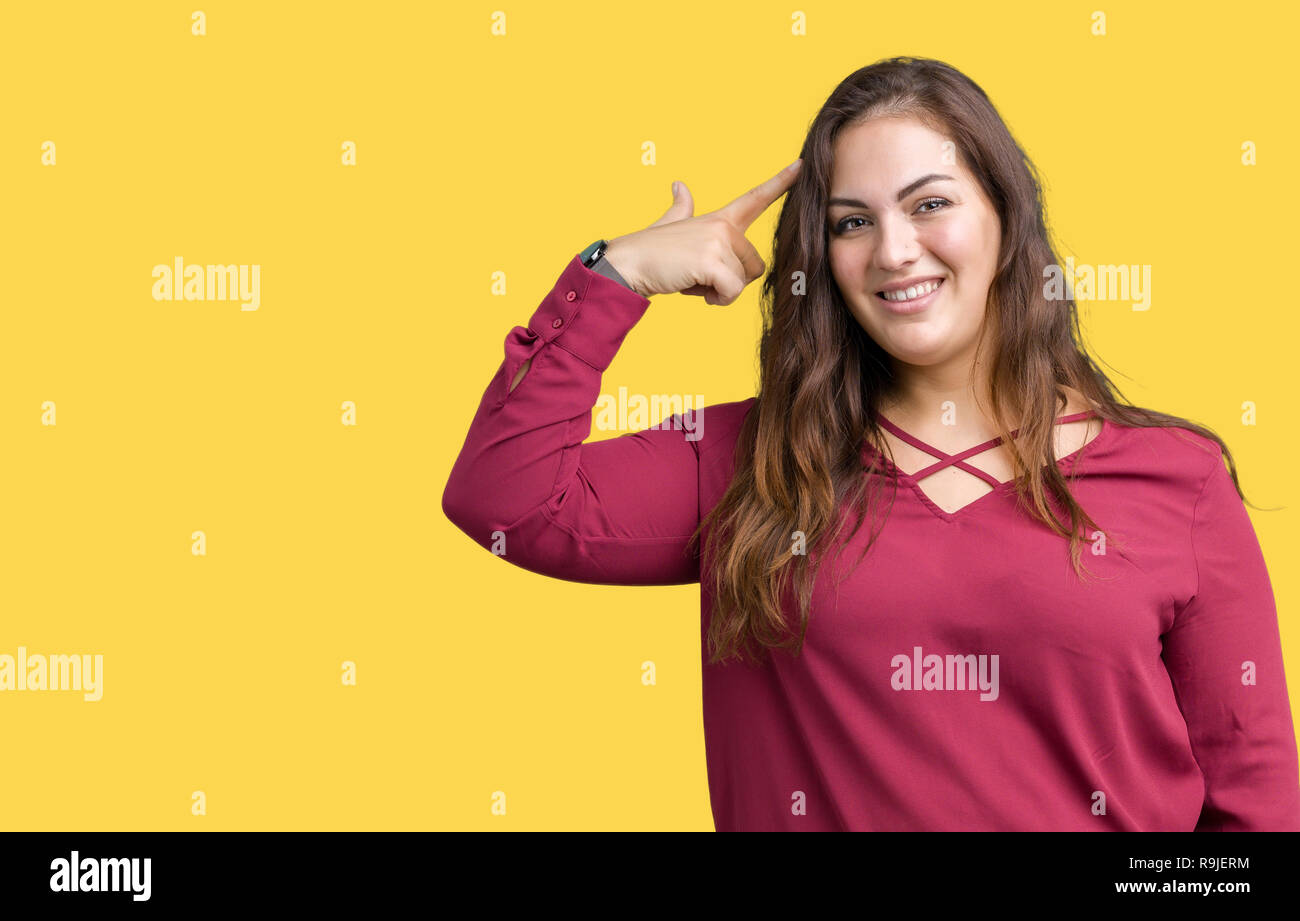 Beautiful plus size young woman over isolated background Smiling pointing to head with one finger, great idea or thought, good memory Stock Photo