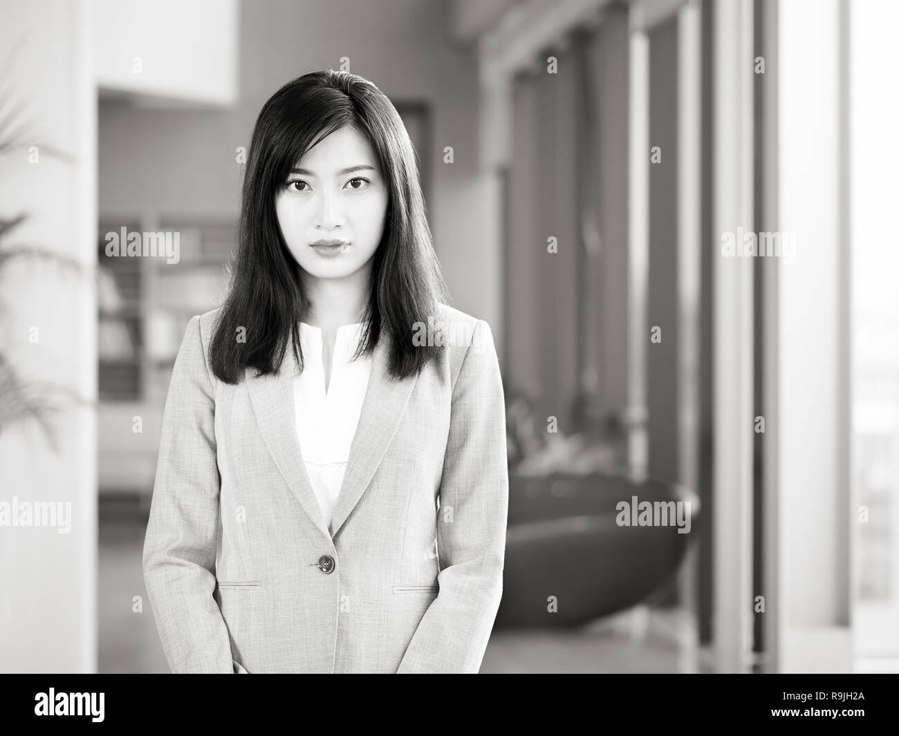office portrait of a young asian business woman looking at camera, black and white. Stock Photo