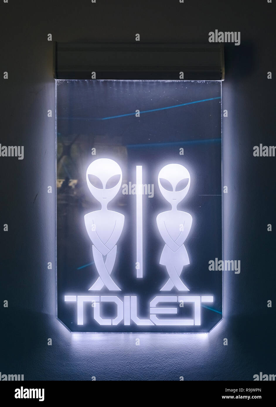 Illuminated alien sign, futuriistic alien toilet sign Stock Photo - Alamy