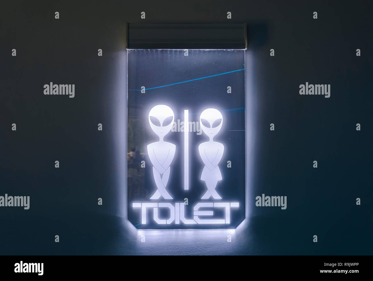 Illuminated alien sign, futuriistic alien toilet sign Stock Photo