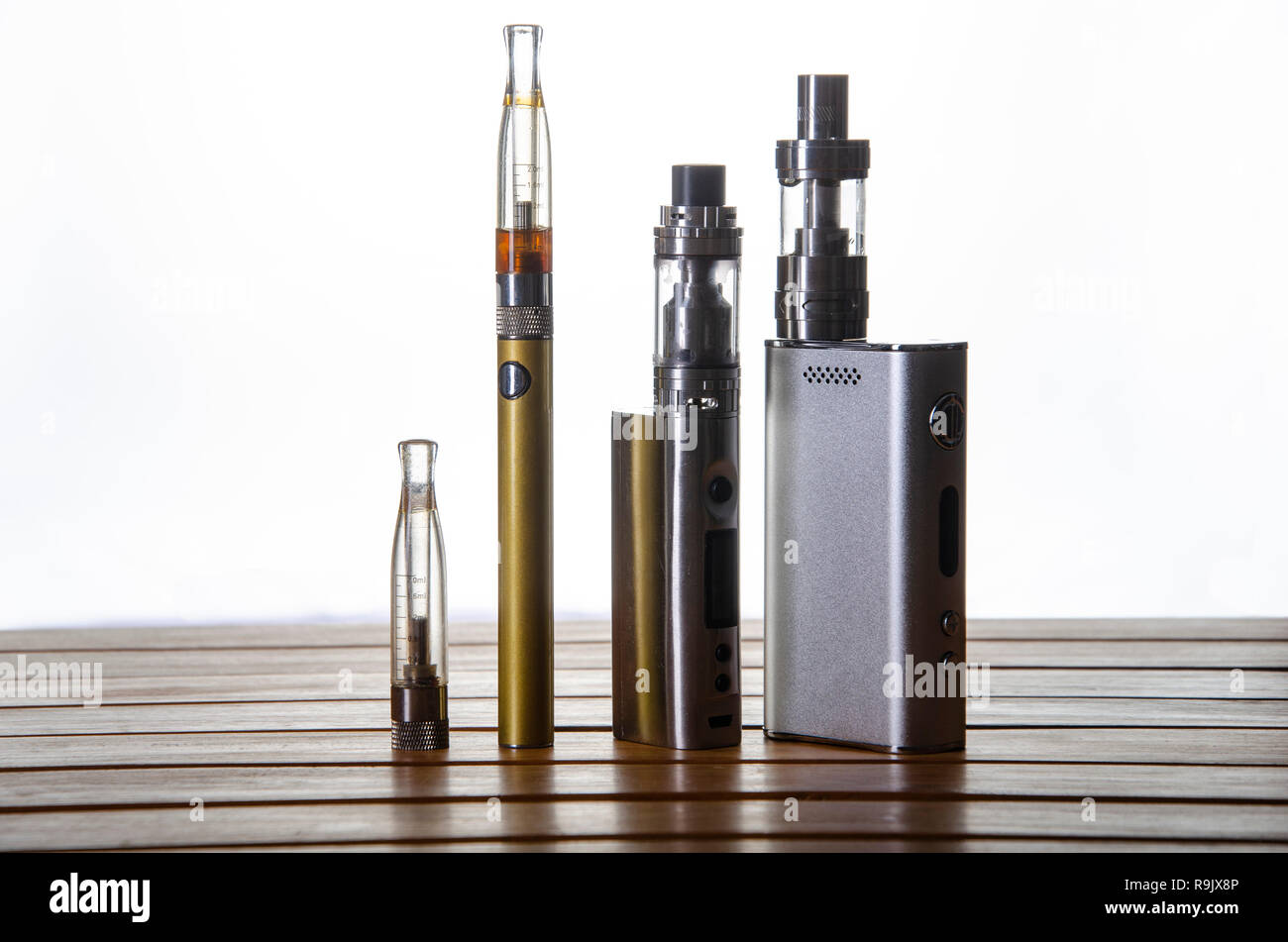 Popular vaping e cig devices mod.electronic cigarette over wooden  background. vaporizer e-cig old device model Stock Photo - Alamy