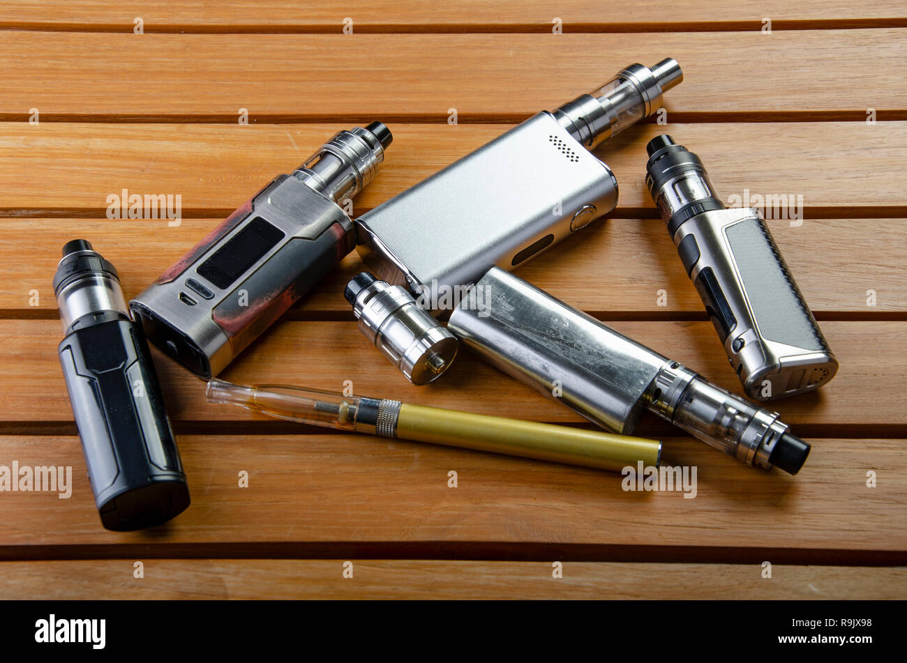Alter Vape Popular vaping e cig devices mod.electronic cigarette over  wooden background. vaporizer e-cig old device model Stock Photo