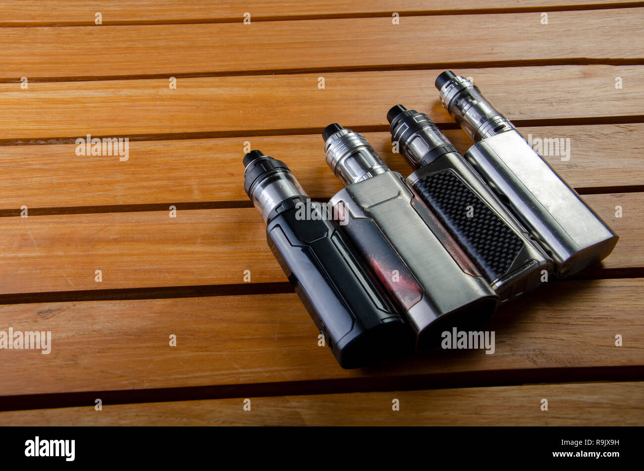 Popular vaping e cig devices mod.electronic cigarette over wooden  background. vaporizer e-cig old device model Stock Photo - Alamy
