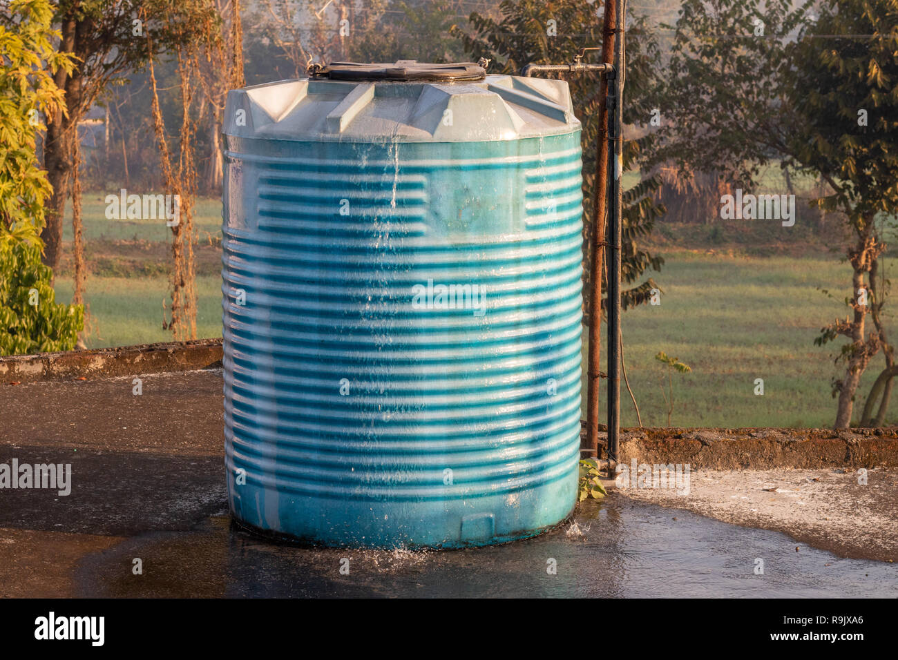 Water tank overflowing, wasting water Stock Photo