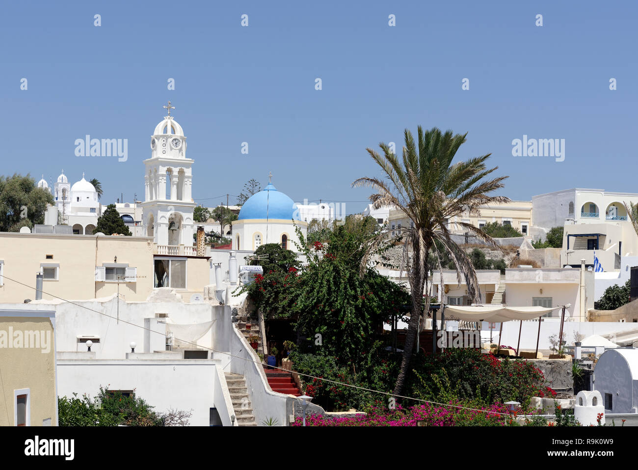 Church domes and belltowers and whitewashed buildings dominate the skyline of the village of Megalochori, Santorini, Greece. Stock Photo