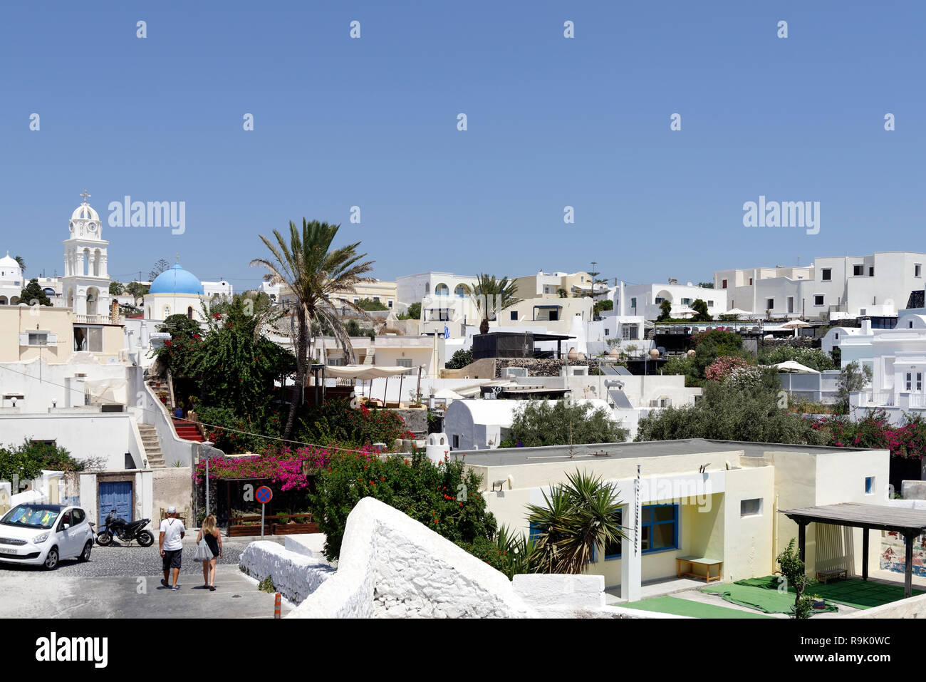 Church domes and belltowers and whitewashed buildings dominate the skyline of the village of Megalochori, Santorini, Greece. Stock Photo