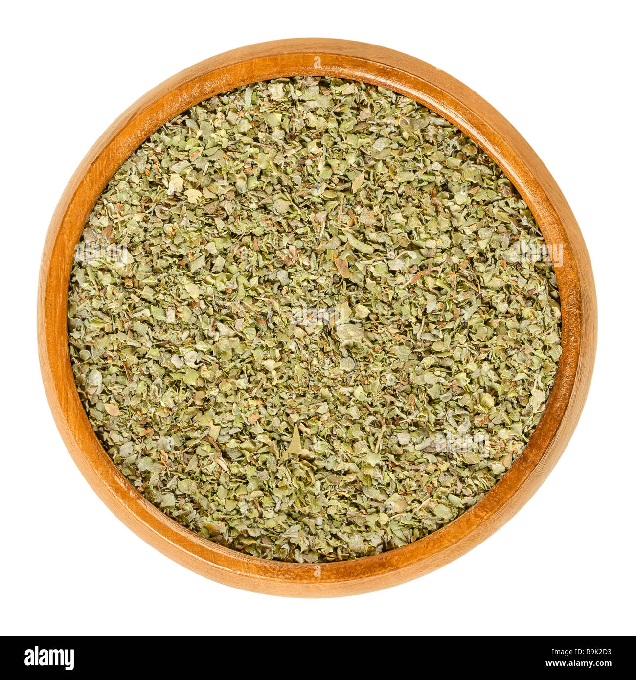 Dried marjoram in wooden bowl. Origanum majorana, also sweet, knotted or pot marjoram. Green herb and spice with sweet pine and citrus flavors. Stock Photo