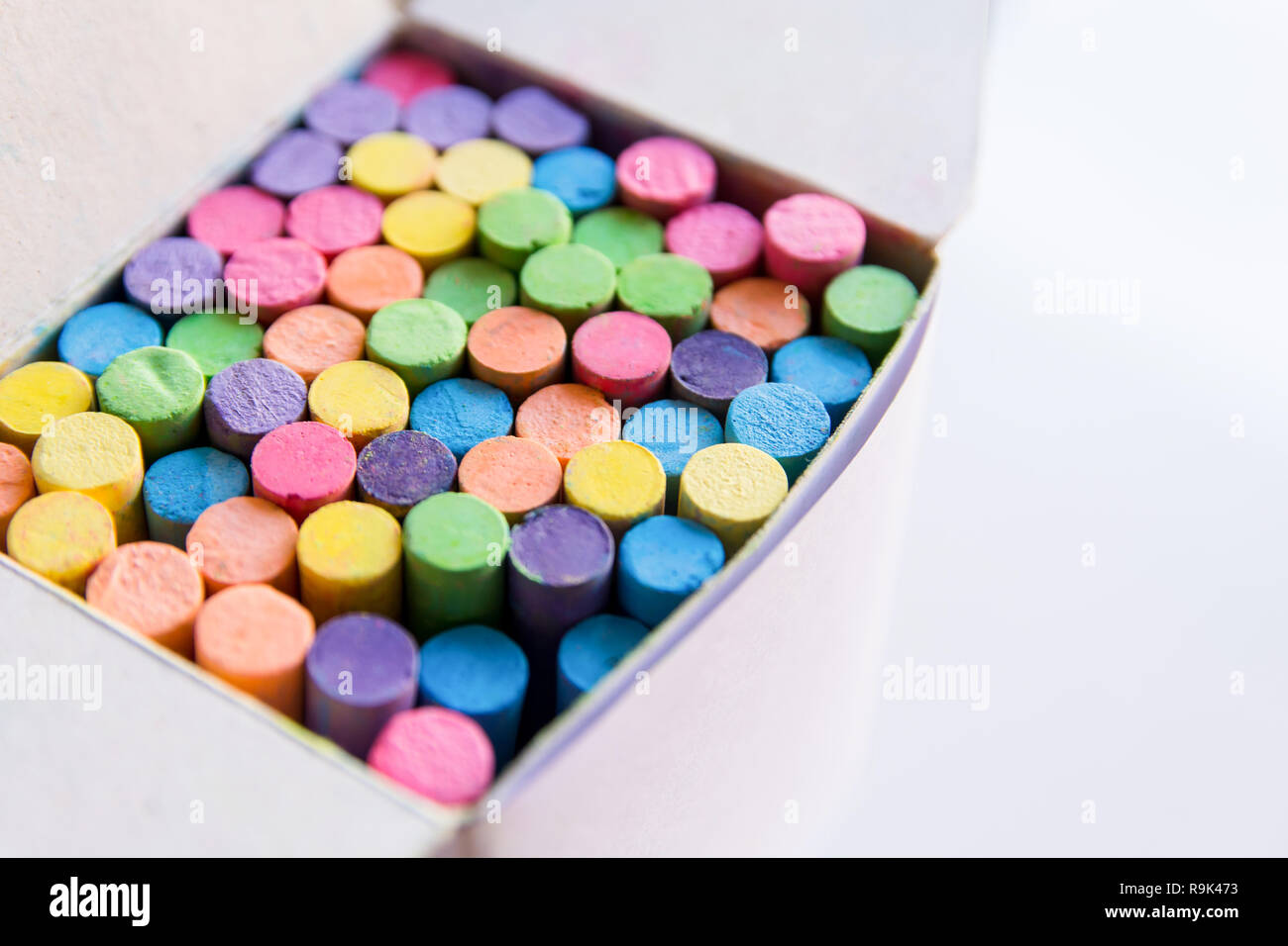 Colorful chalk in a cardboard box, Box of chalk on white background