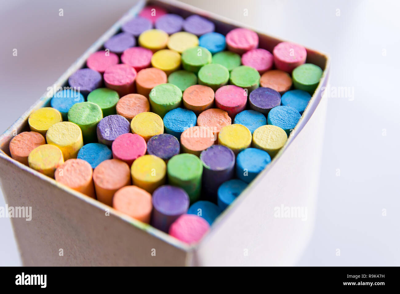 Colorful chalk in a cardboard box, Box of chalk on white background