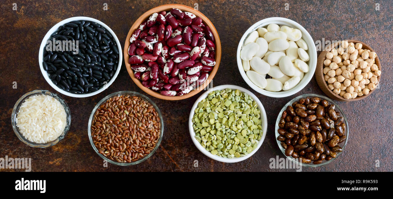 Healthy food, dieting, nutrition concept, vegan protein source. Assortment of colorful raw legumes: green peas, beans, chickpeas, rice in bowls. Banne Stock Photo
