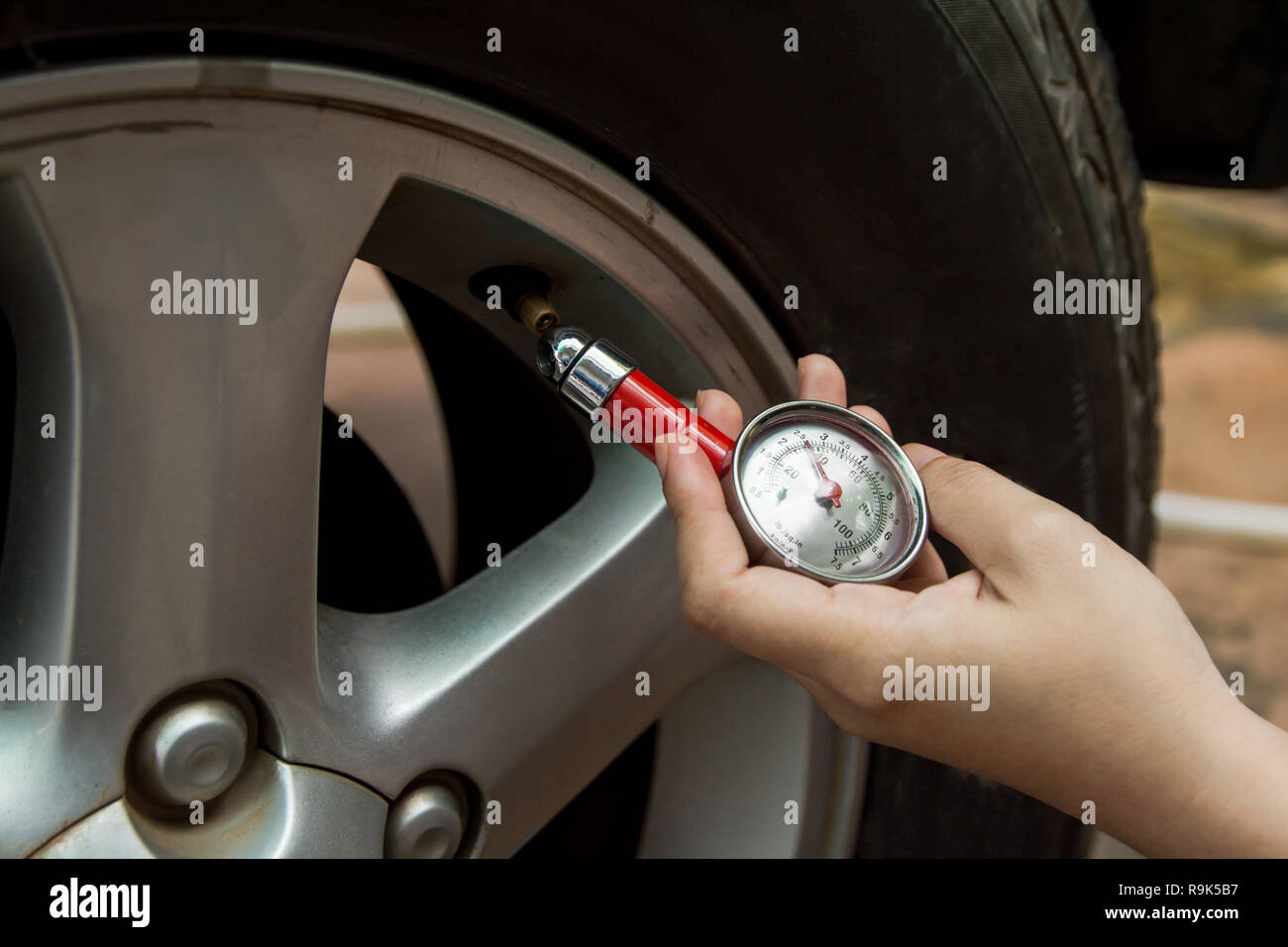 Tire pressure gauge : Hand holding pressure gauge checking air pressure ...