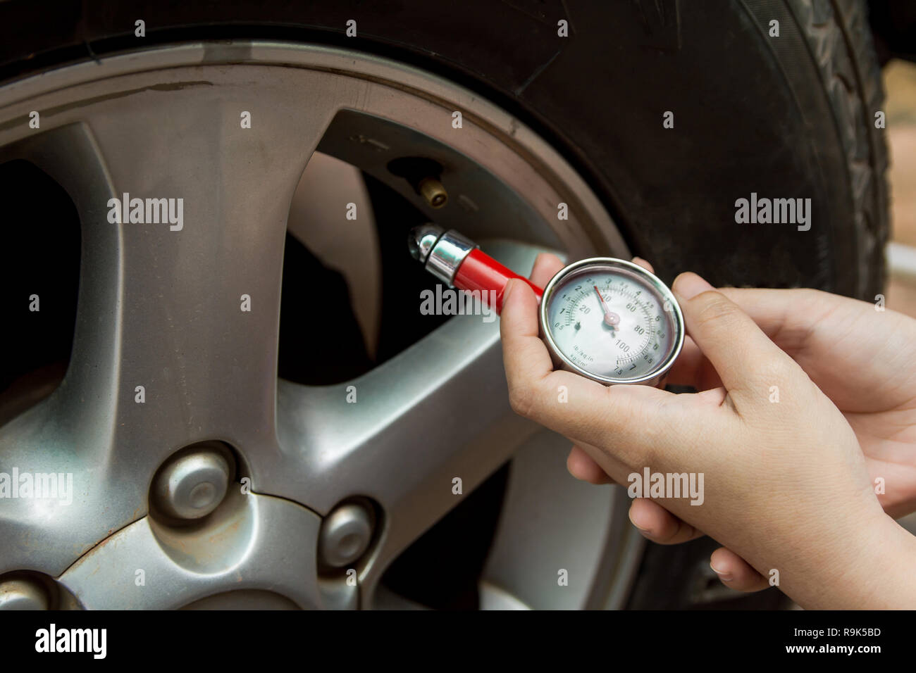 Tire pressure gauge : Hand holding pressure gauge checking air pressure ...