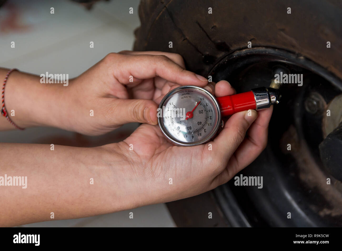 Tire pressure gauge Hand holding pressure gauge checking air pressure for car tire. Safe