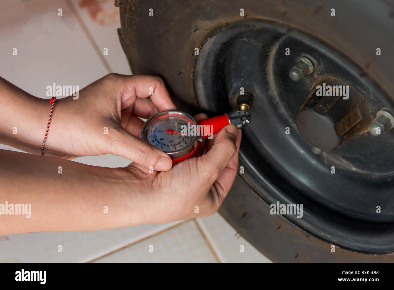 Tire pressure gauge : Hand holding pressure gauge checking air pressure ...