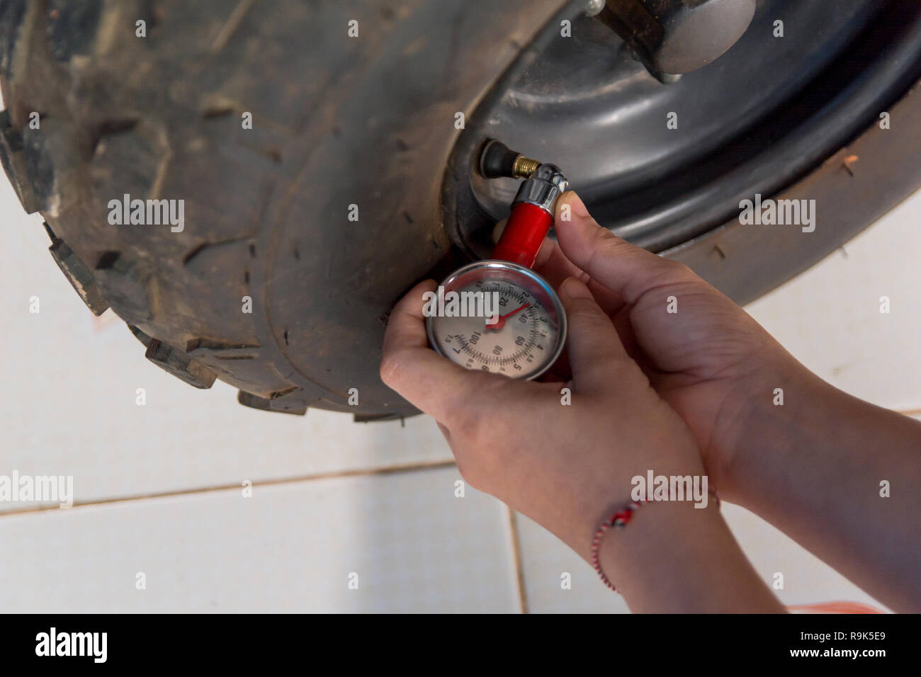 Tire pressure gauge : Hand holding pressure gauge checking air pressure ...