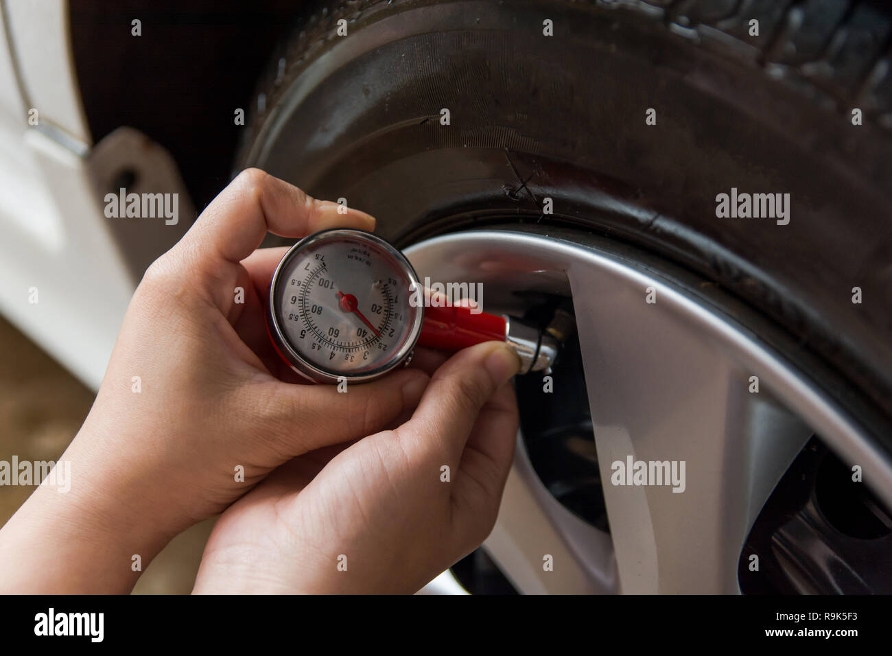 Tire pressure gauge : Hand holding pressure gauge checking air pressure ...