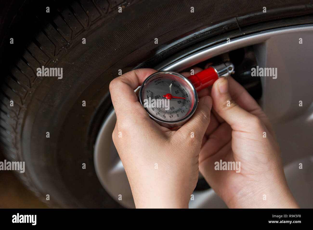 Tire pressure gauge : Hand holding pressure gauge checking air pressure ...