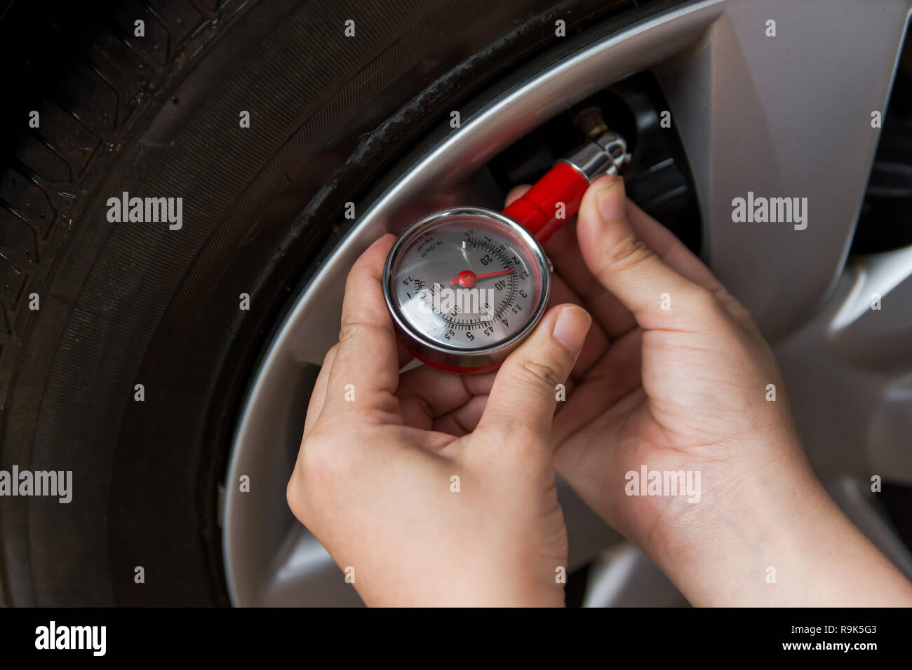 Tire pressure gauge : Hand holding pressure gauge checking air pressure ...