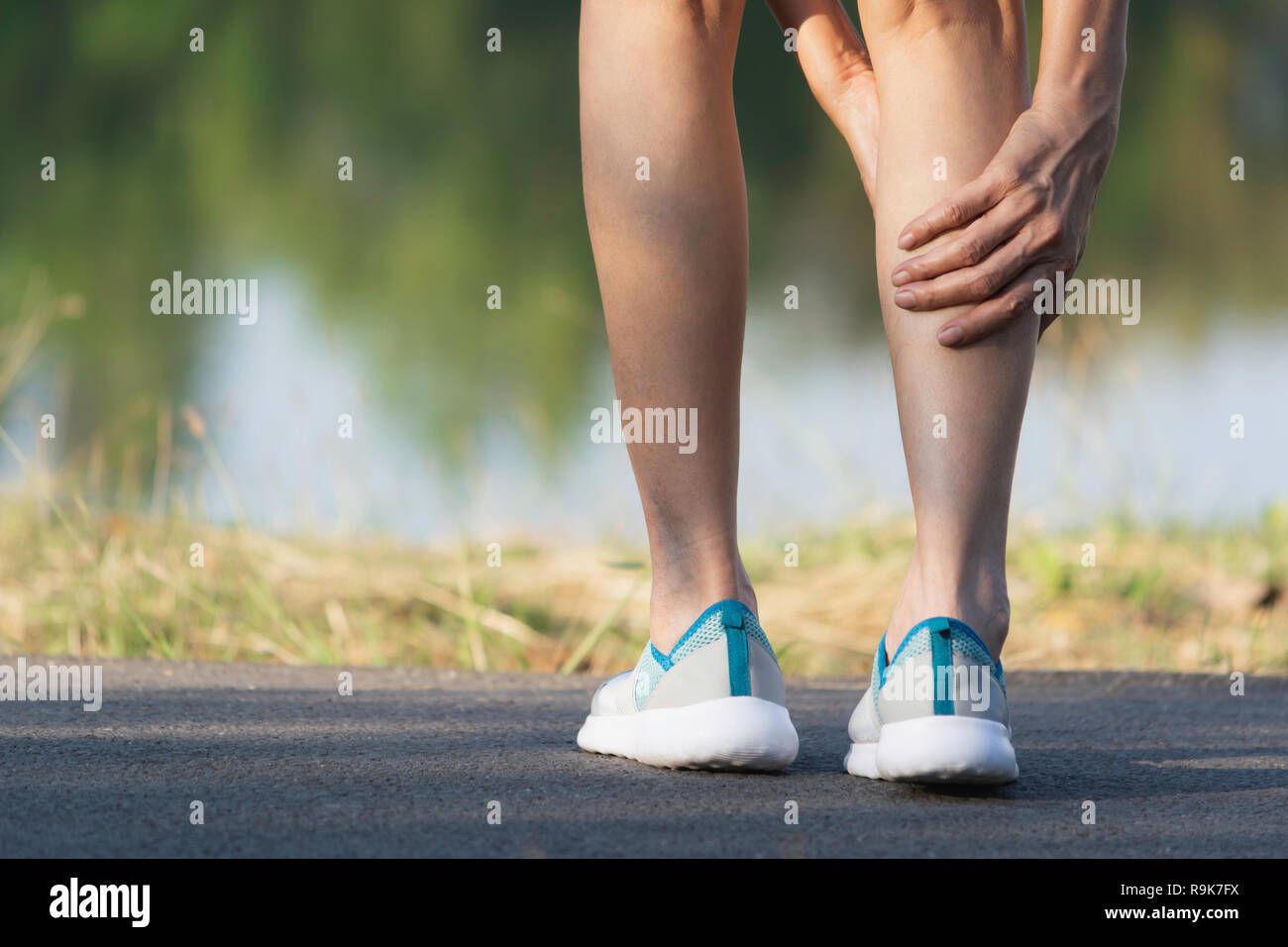 The female clings to a bad leg. The pain in her leg. Healthcare and painful concept. Stock Photo