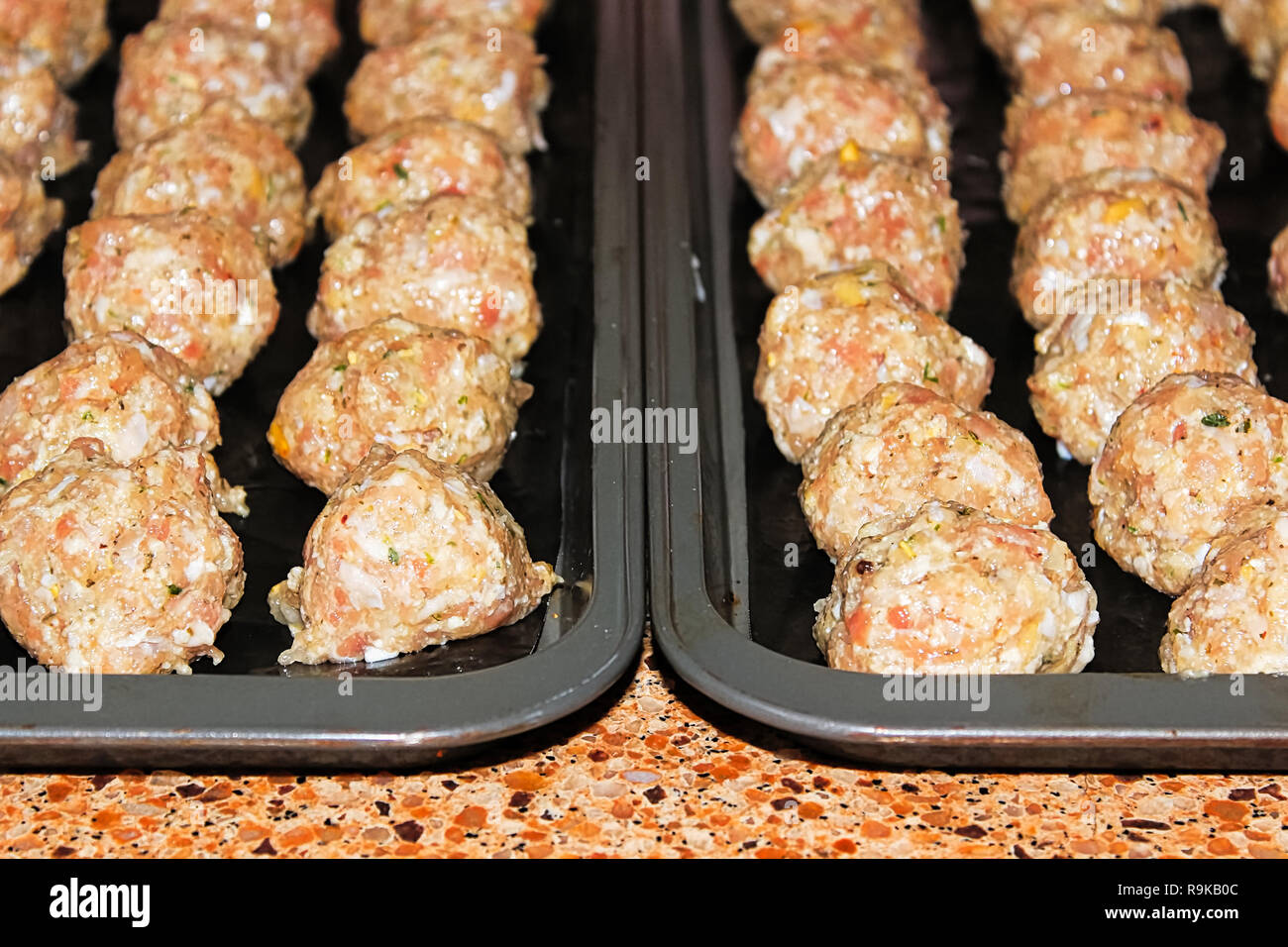 view of raw turkey pine nut meatballs on cookie sheets Stock Photo