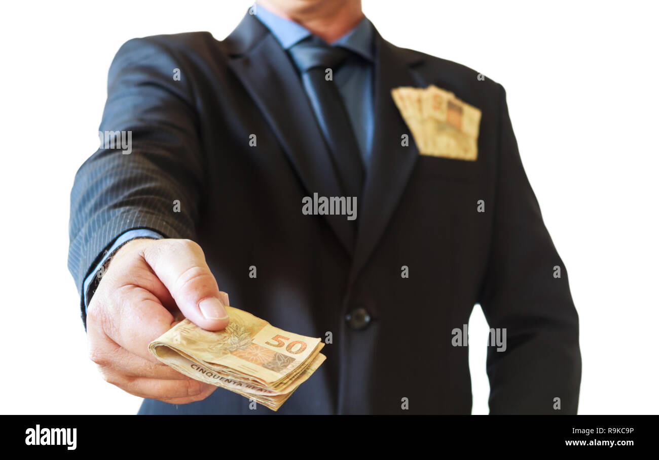 Business man holding money brazilian in his hands and in suit pocket. White background. Stock Photo