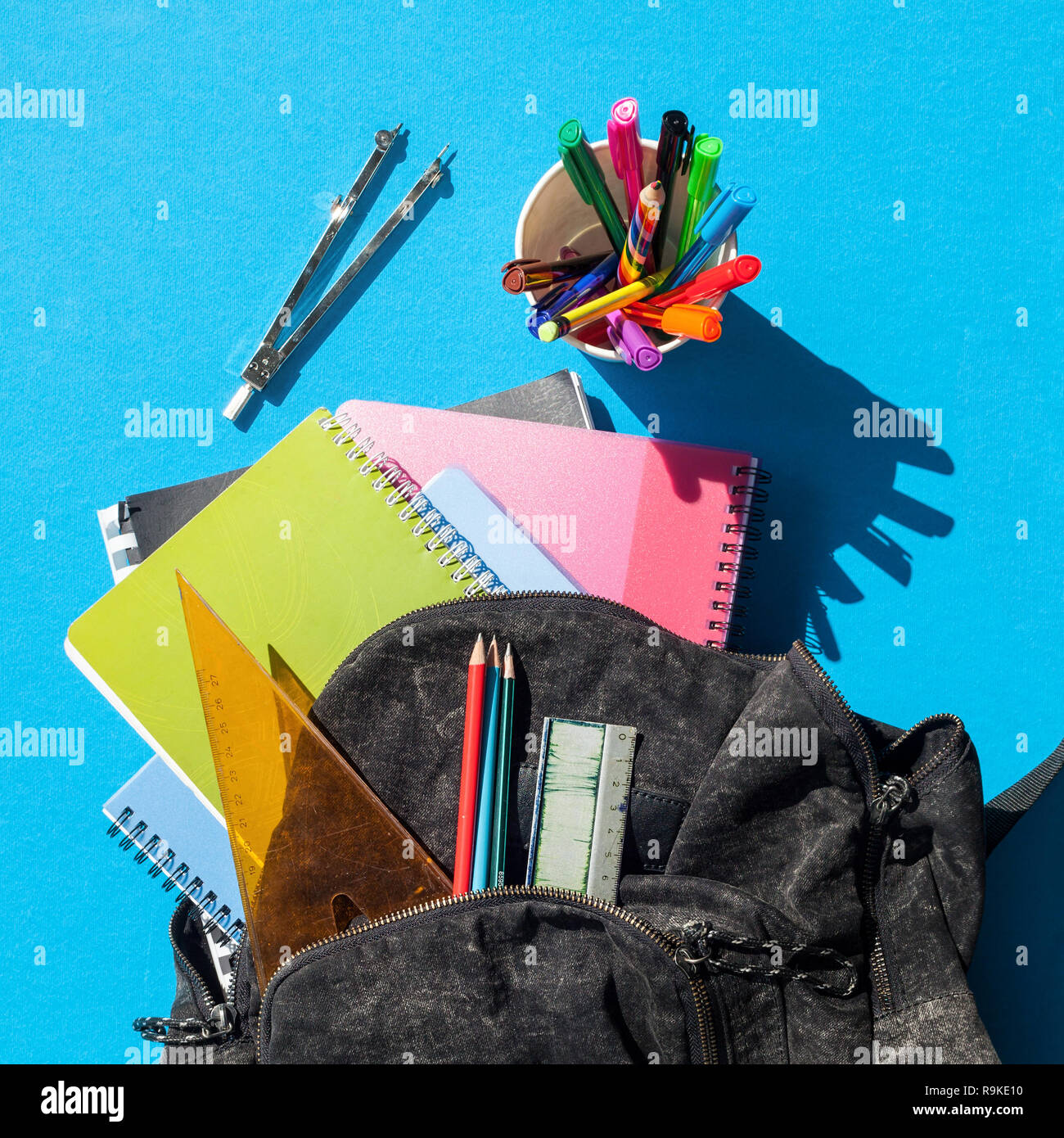 Square format of an overview of a schoolbag contents, blue background Stock Photo