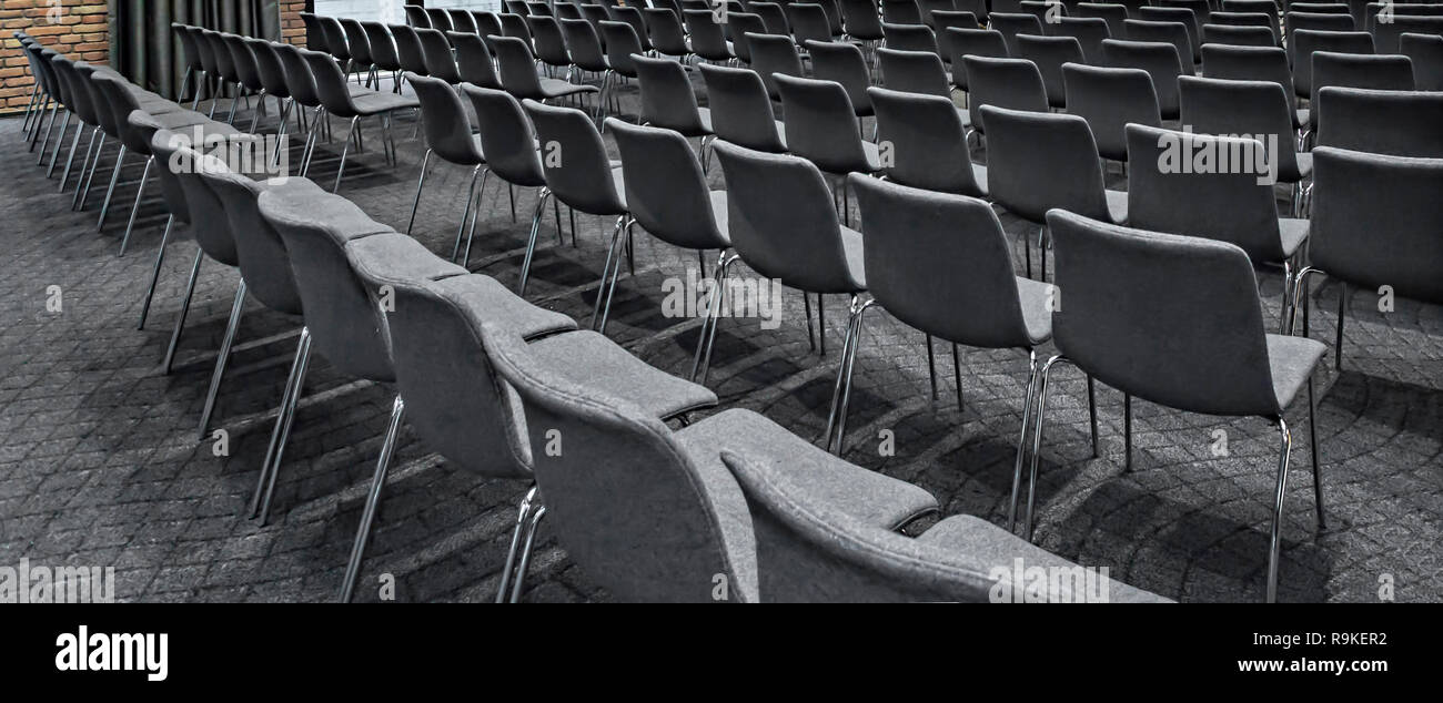 Group of empty gray chairs in modern conference hall - presentation room for seminars Stock Photo