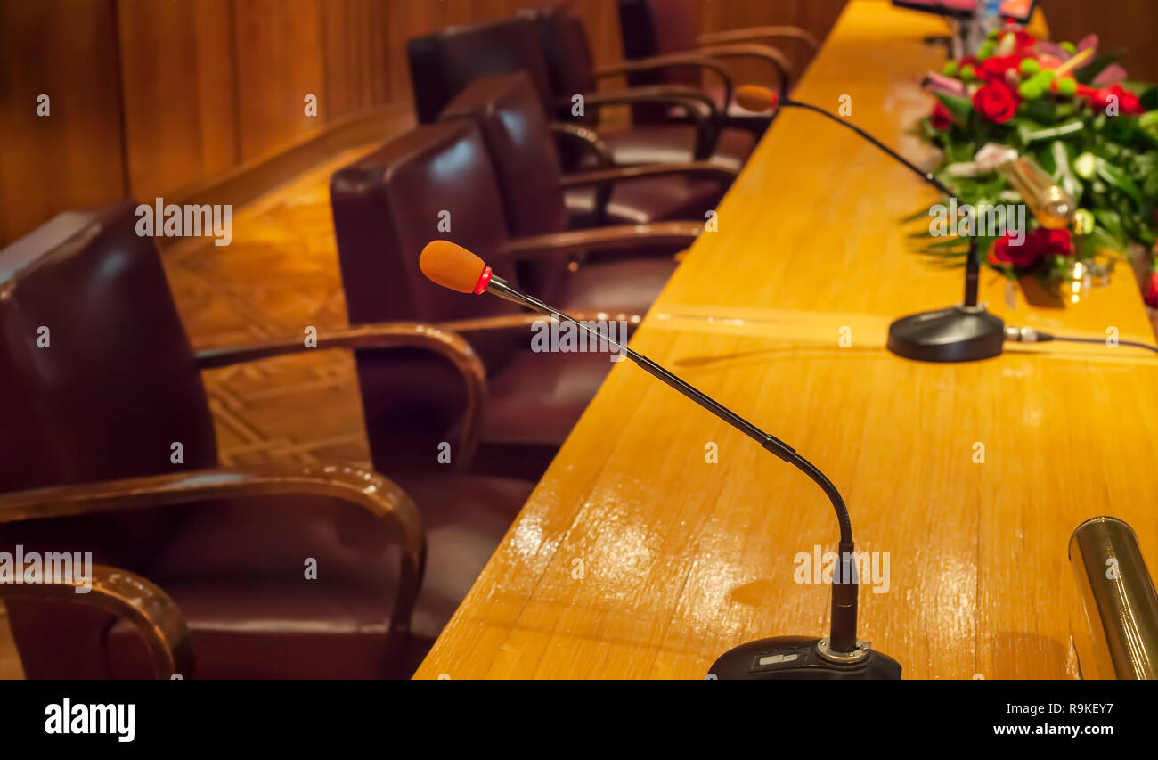 Close up of microphones and empty chairs in conference hall ready for public speaking. Academic gathering Stock Photo