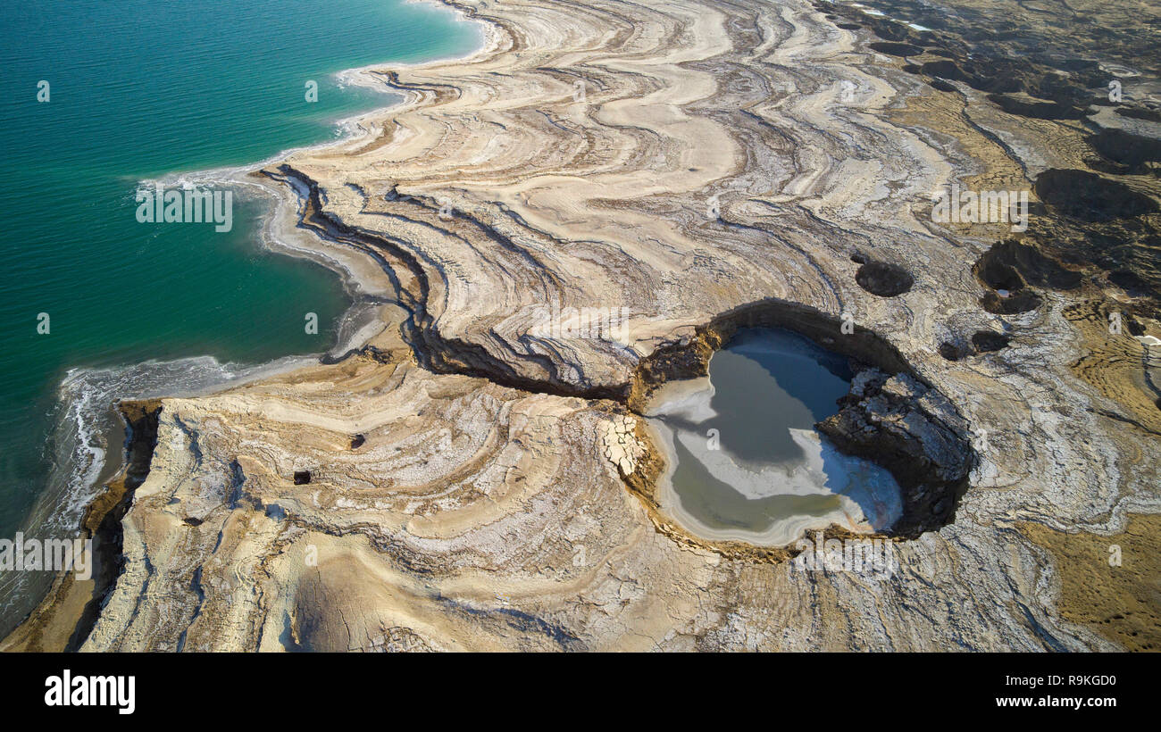 Aerial Photography with a drone. Elevated view of sink holes on the shore of the Dead Sea, Israel. The sink holes are caused by the rapidly receding w Stock Photo