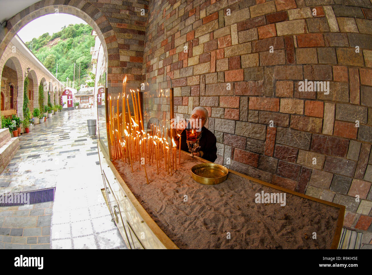 Lighting candles in a monastery in Greece Stock Photo