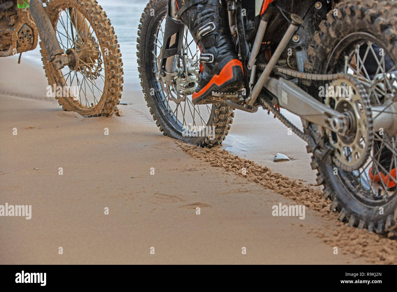 motorcycle wheels leave footprints in the wet sand on the beach Stock ...